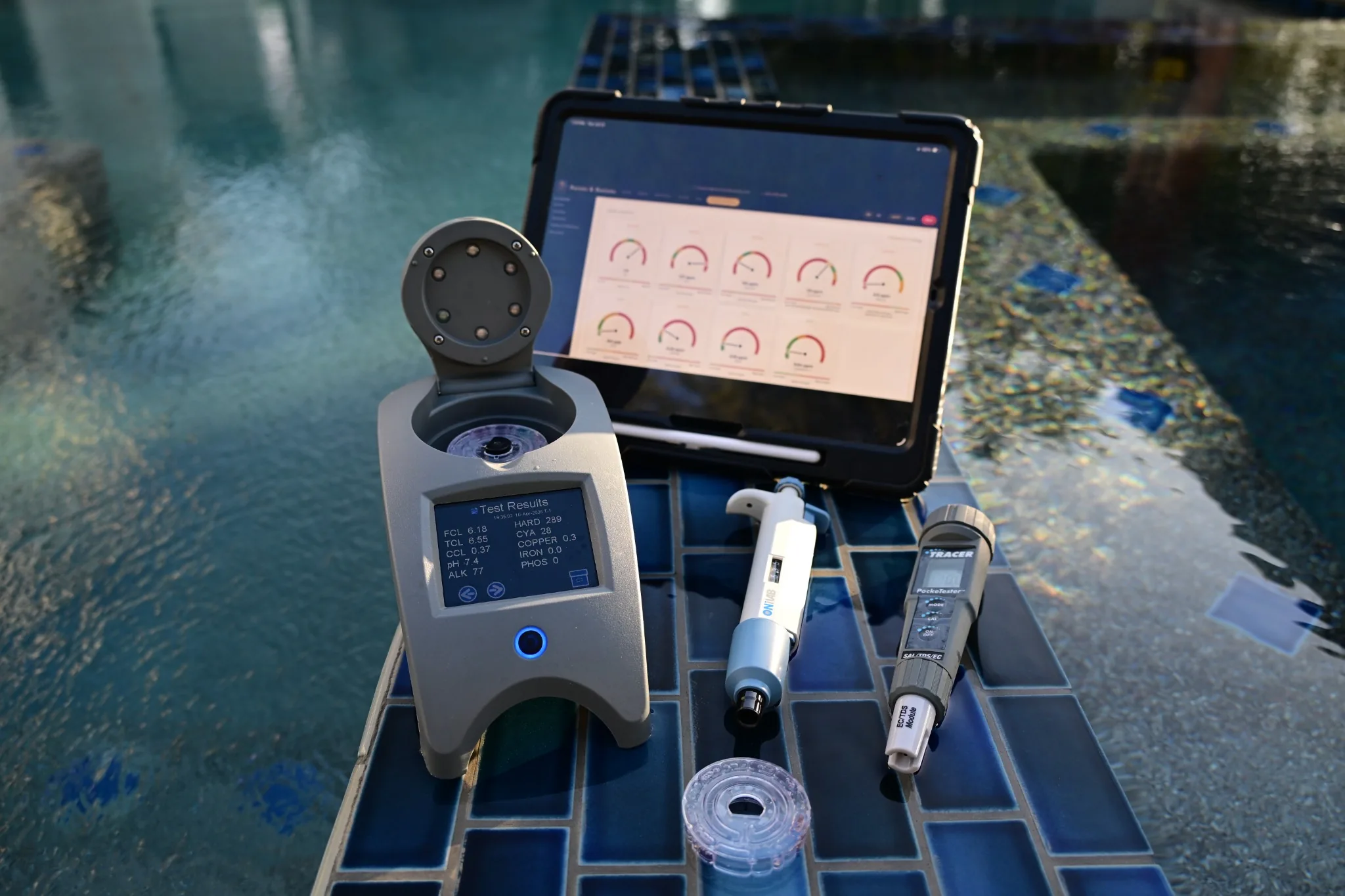 Professional digital pool-water testing equipment beside a Barons & Buttons client dashboard